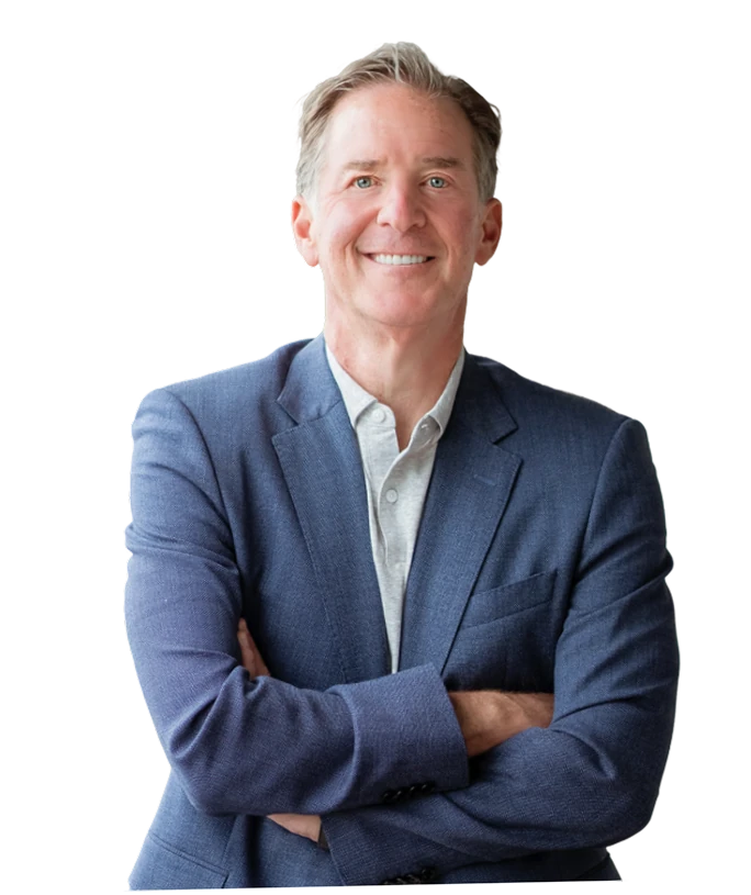 Mark Zides smiling with his arms crossed, wearing a navy blazer.